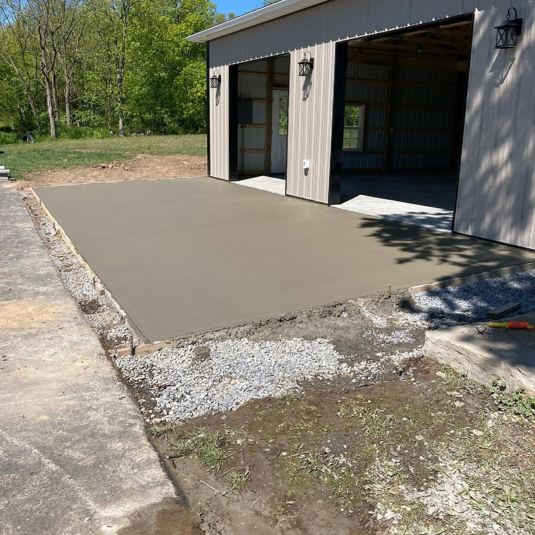 A fresh pour of concrete outside of a garage.
