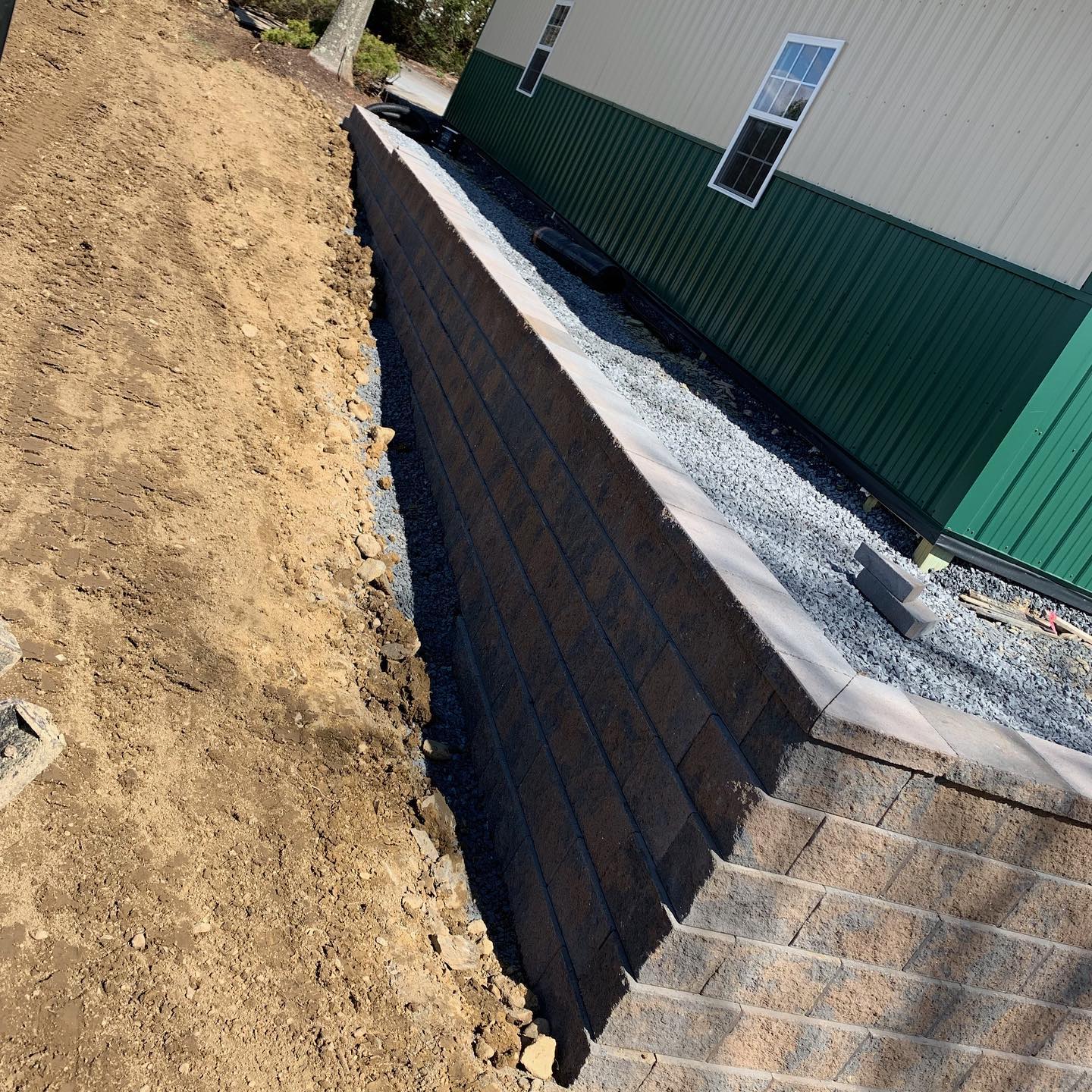 A large retaining wall alongside an outdoor garage.