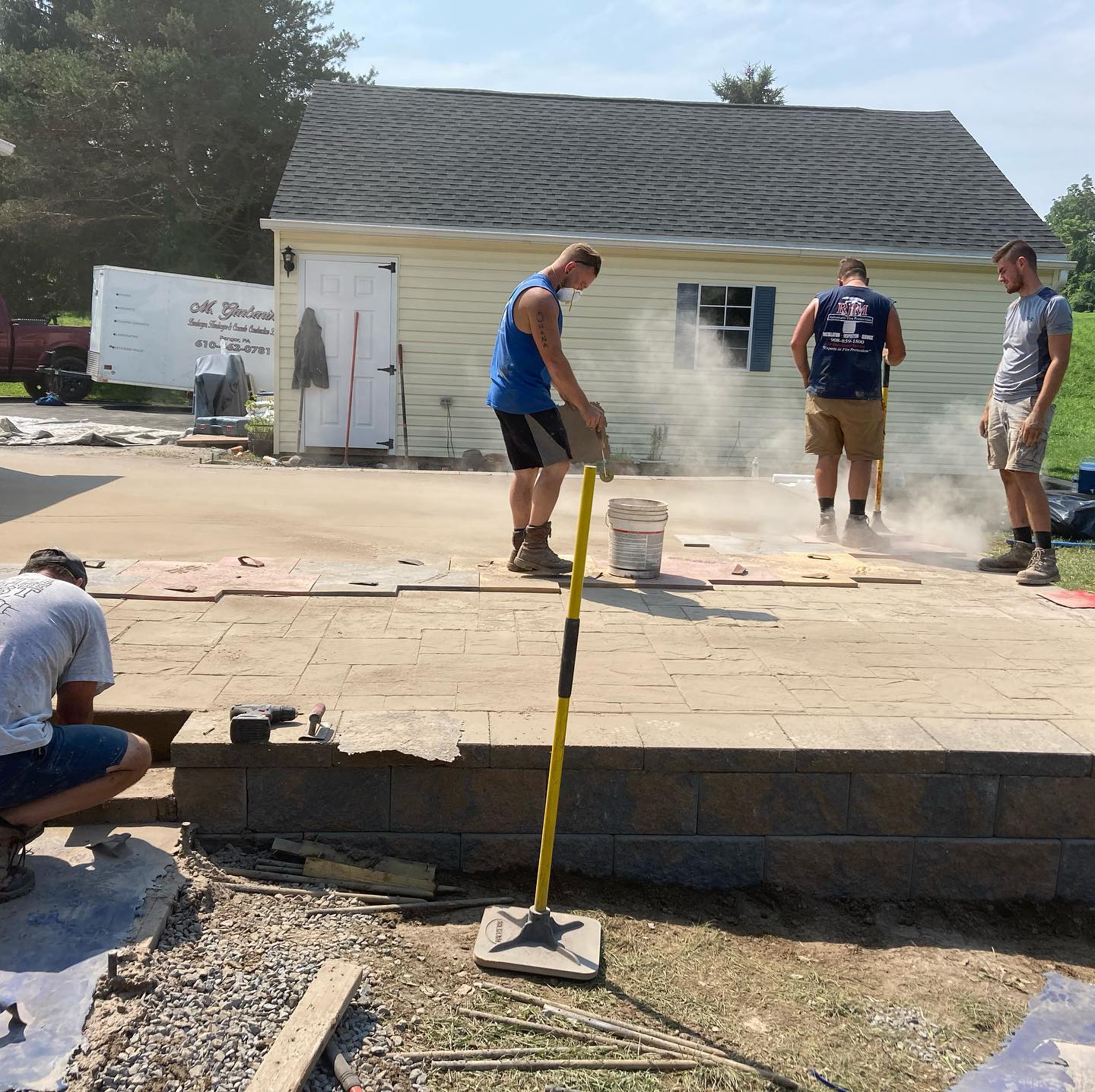 A group of men stamping concrete.