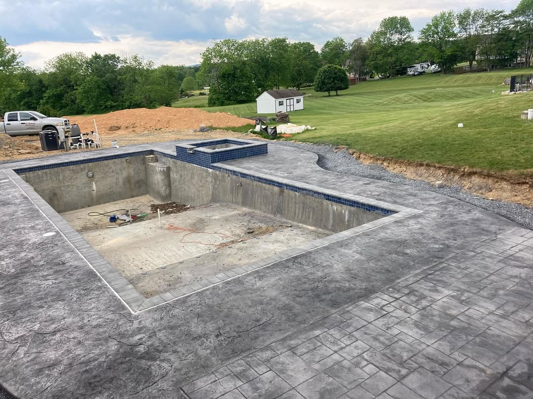 A concrete patio outside of a pool.