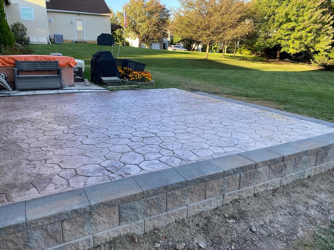 A concrete patio with a stamped concrete pattern.