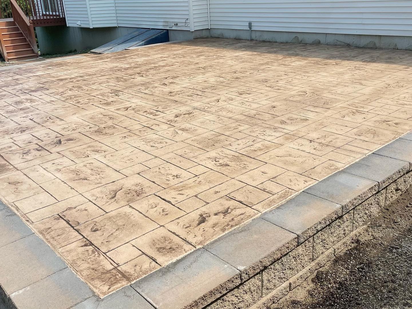 A large square concrete patio stamped with a block pattern.